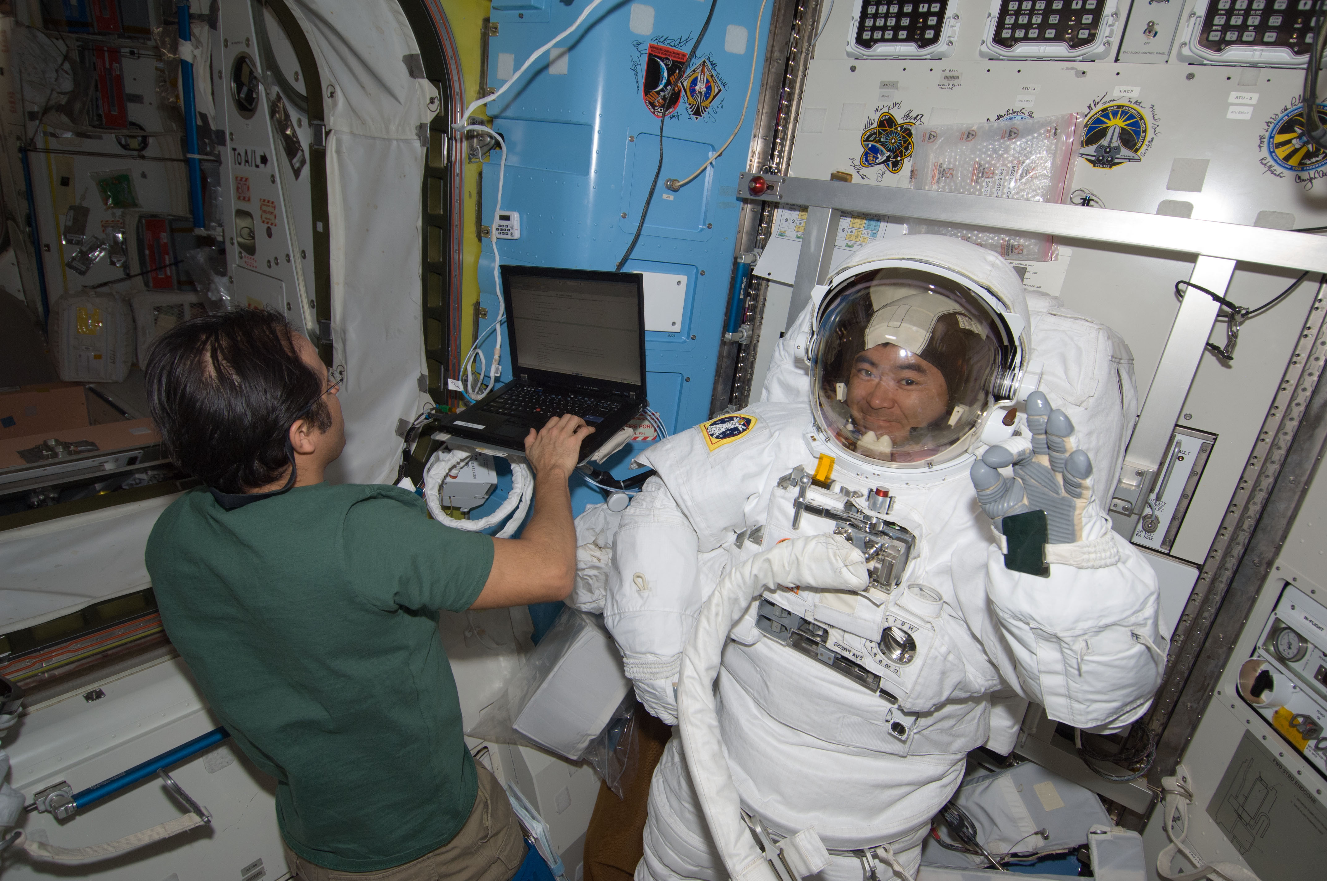 Japanese astronaut Akihiko Hoshide of JAXA waves while testing his spacesuit inside the International Space Station ahead of an Aug. 30, 2012 spacewalk with crewmate Sunita Williams of NASA.