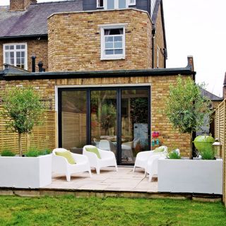 garden area with glass door and brick wall with plastic arm chair