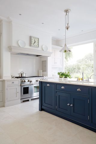White kitchen with a blue island by Tom Howley