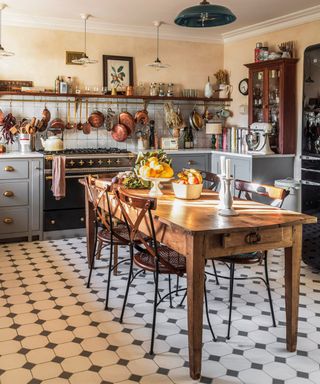 A French country style kitchen with a traditional wooden kitchen table at the center