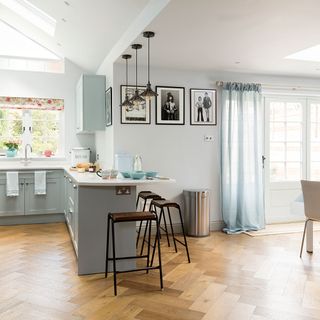 Galley kitchen makeover with pale blue cabinets roof lantern and parquet flooring
