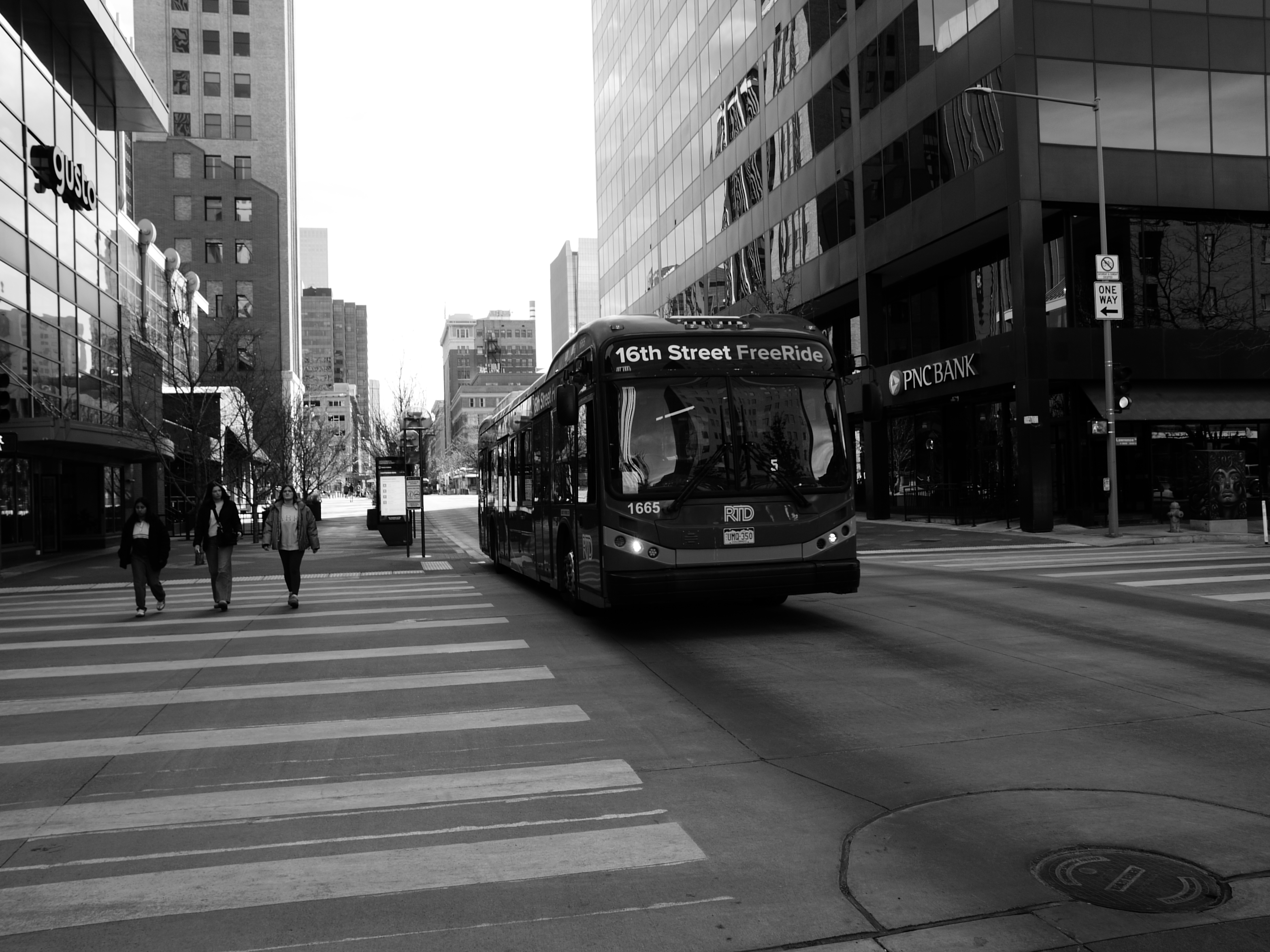 A black and white street photo of a bus, shot on the Lumix L1