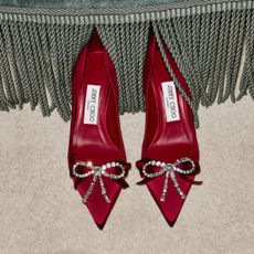 a pair of red satin jimmy choo heels with diamante bows