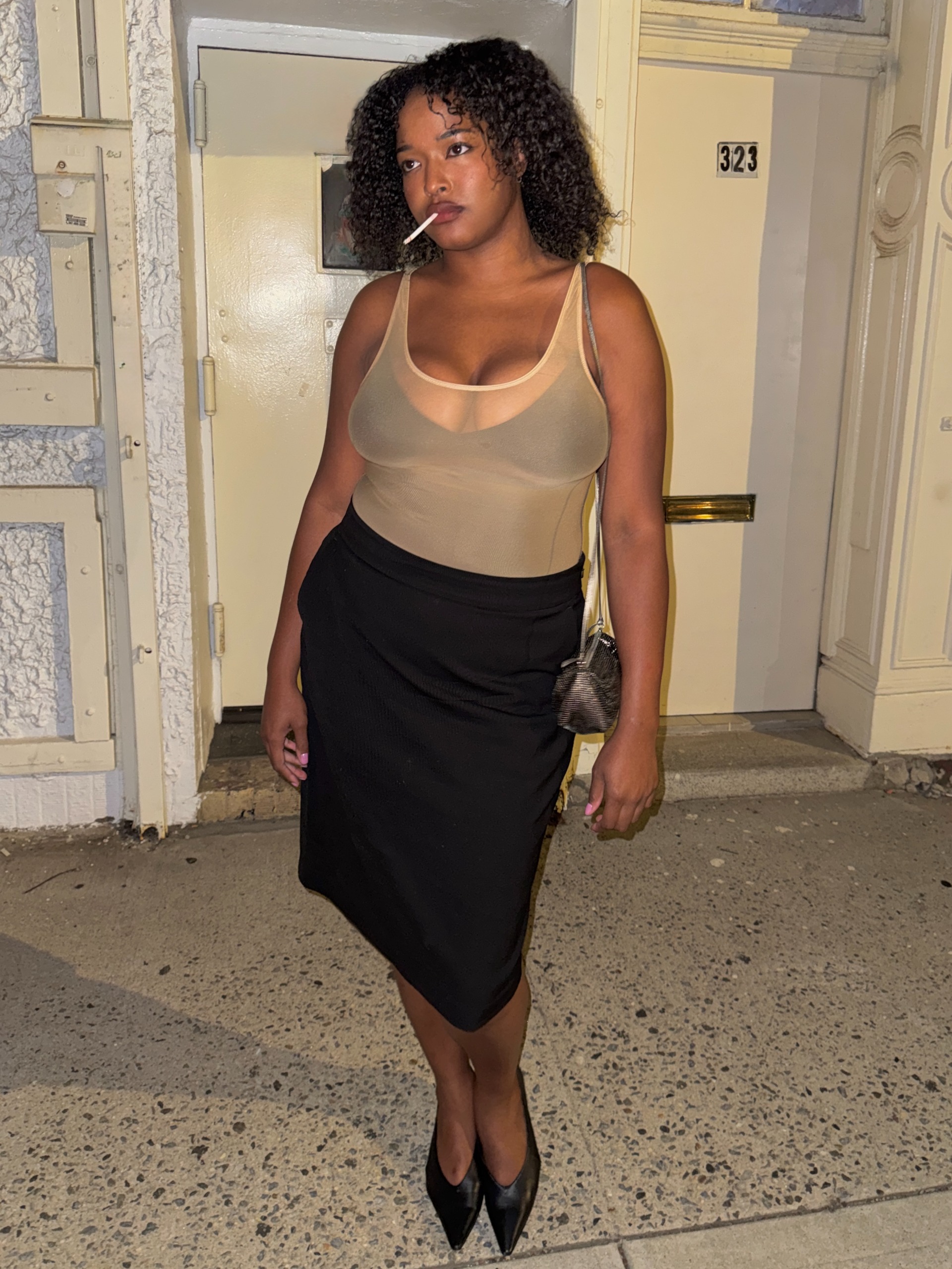 IMANI RANDOLPH 3.JPG: Natalie Hammond era's dressing 2026. Imani wears a sheer tank top with a black bra peaking through, a black midi skirt and black pointed-toe heels. Imani provided this image.