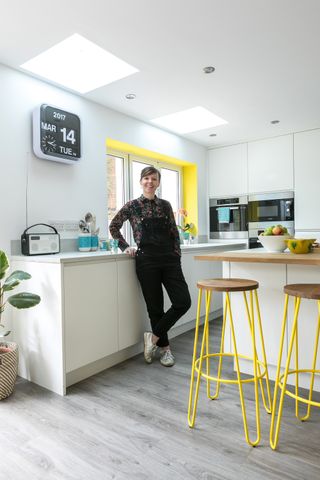 homeowner standing in a modern white kitchen