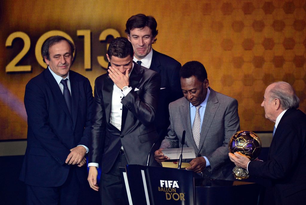 Real Madrid's Portuguese forward Cristiano Ronaldo (C) reacts as he receives the 2013 FIFA Ballon d'Or Player of the Year award from Brazilian football legend Pele (2nd-R), France Football President Francois Moriniere (back-C), FIFA President Sepp Blatter (R) and UEFA President Michel Platini (L) at the FIFA Ballon d'Or Awards Ceremony at the Kongresshaus in Zurich on January 13, 2014.at the FIFA Ballon d'Or Awards Ceremony at the Kongresshaus in Zurich on 13 January 2014.