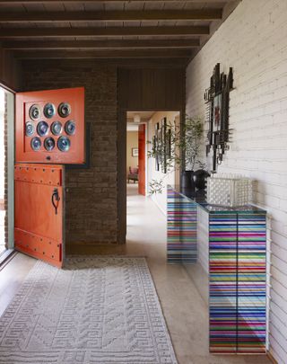 entrance with vermillion orange front door