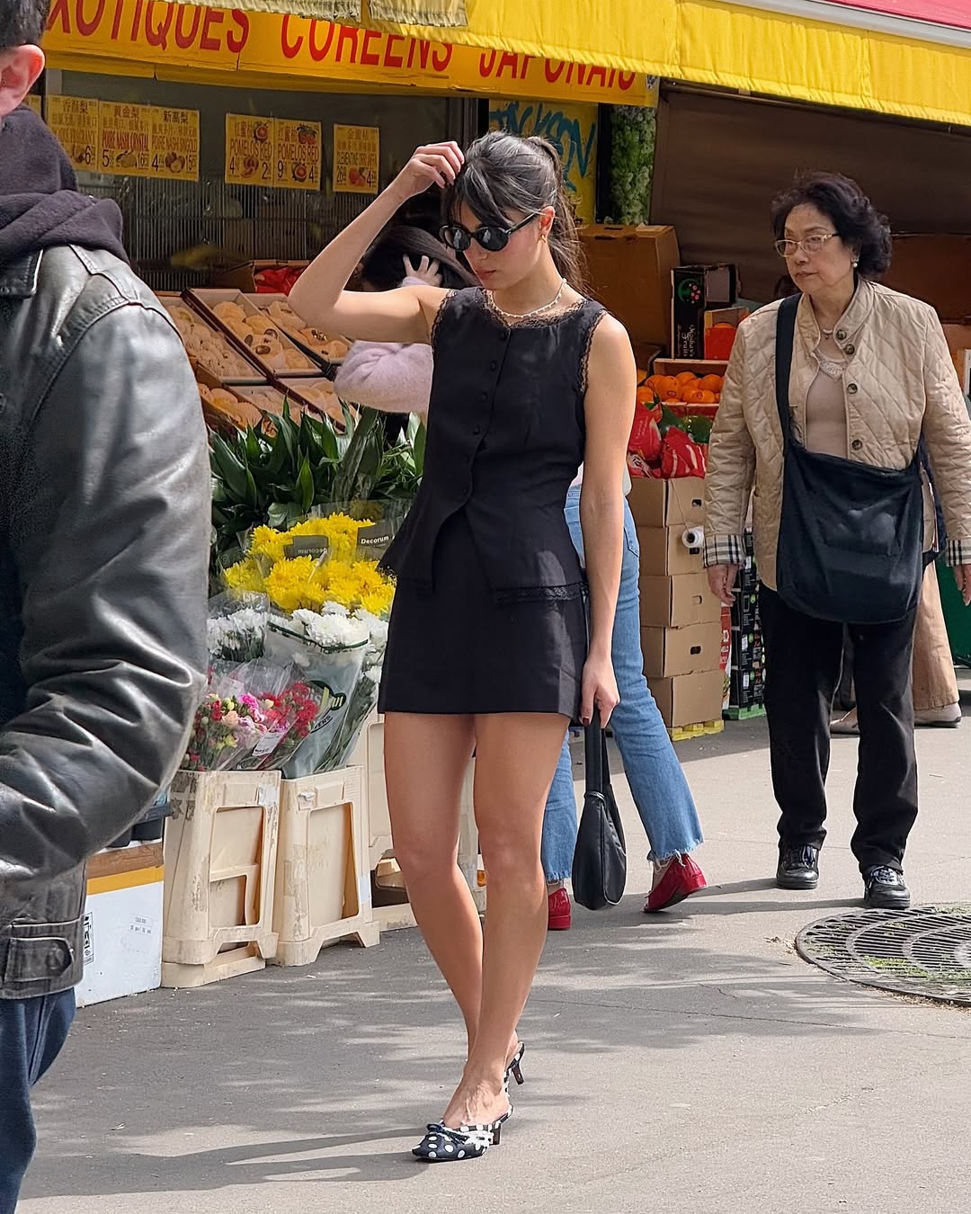Woman wearing a black tailored top and matching miniskirt.