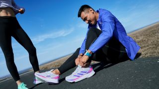 Man putting on Adidas Adizero SL shoes