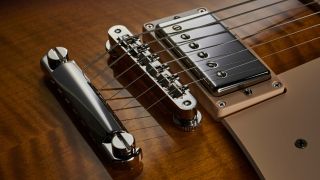 Close up of a tune-o-matic bridge on a Gibson Les Paul