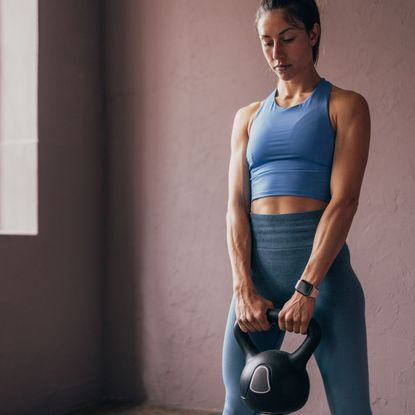 A woman doing one of the best kettlebell workouts at the gym