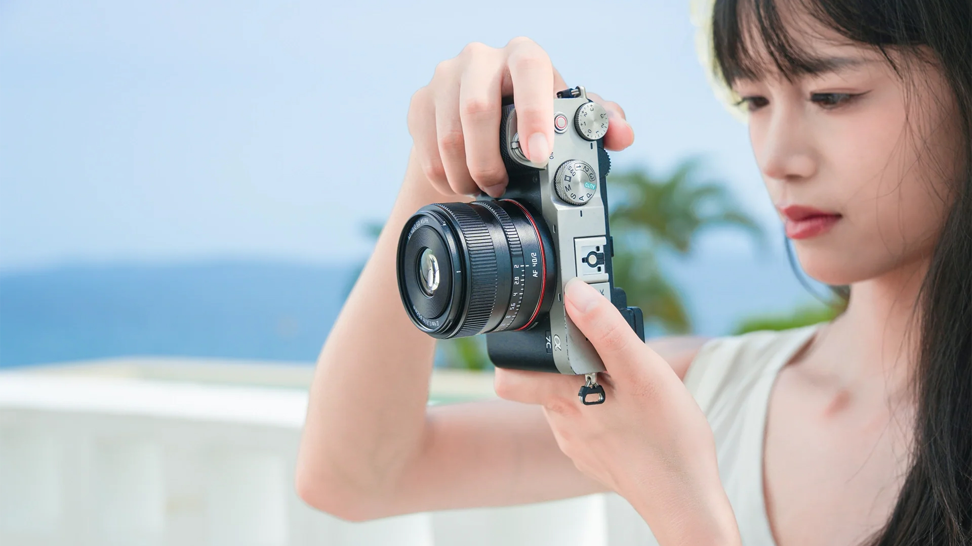 The TTArtisan AF 40mm f/2 held in a photographer's hands