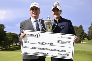 Nelly Korda holds the FIR HILLS SERI PAK Championship trophy and cheque