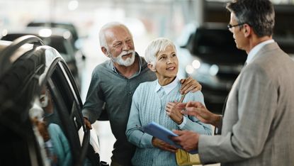 An older couple at the car dealer.