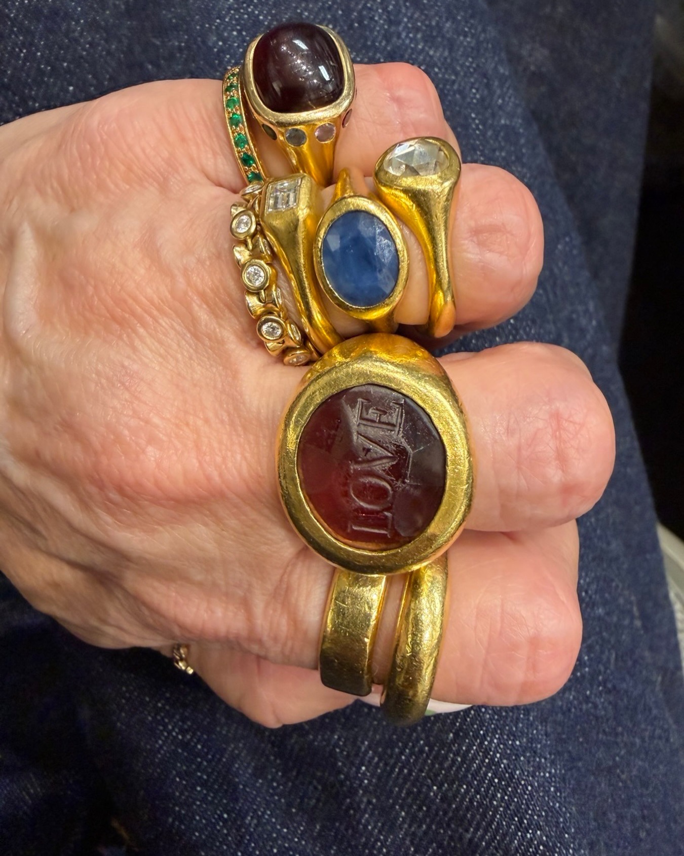 A woman's hand with different statement rings.