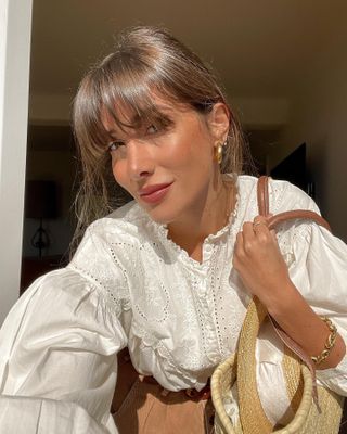 Influencer wears a broderie anglaise blouse.