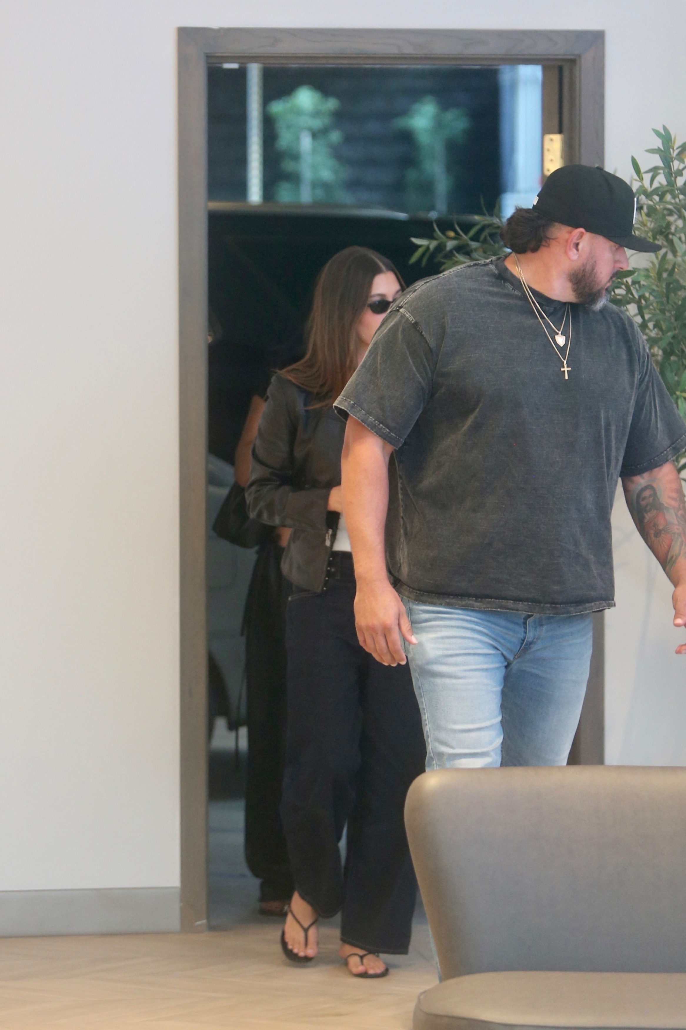 Kylie Jenner and Hailey Bieber wear heeled flip flops and baggy black pants