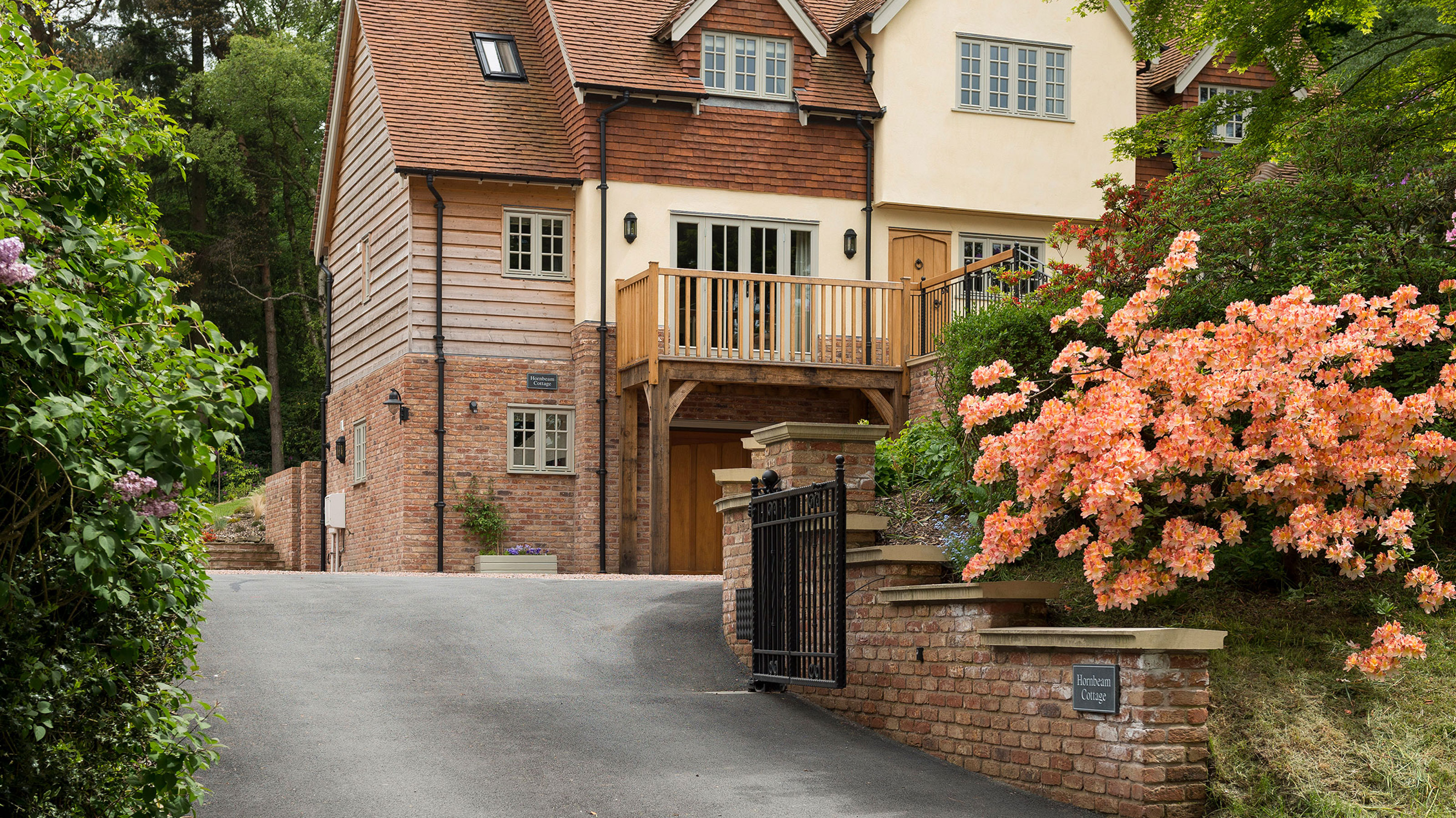 three storey timber frame house with sloping tarmac driveway