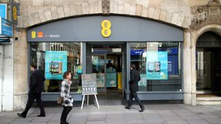 EE high street shop entrance with shoppers passing by