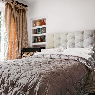 main bedroom with white wall and bed with pillows