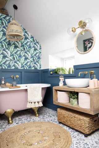Blue panelled bathroom with palm wallpaper, patterned tile flooring, jute rug and rustic wall-hung floating vanity unit