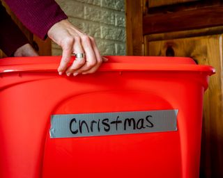 Woman opening a storage box full of Christmas decorations for the holiday season