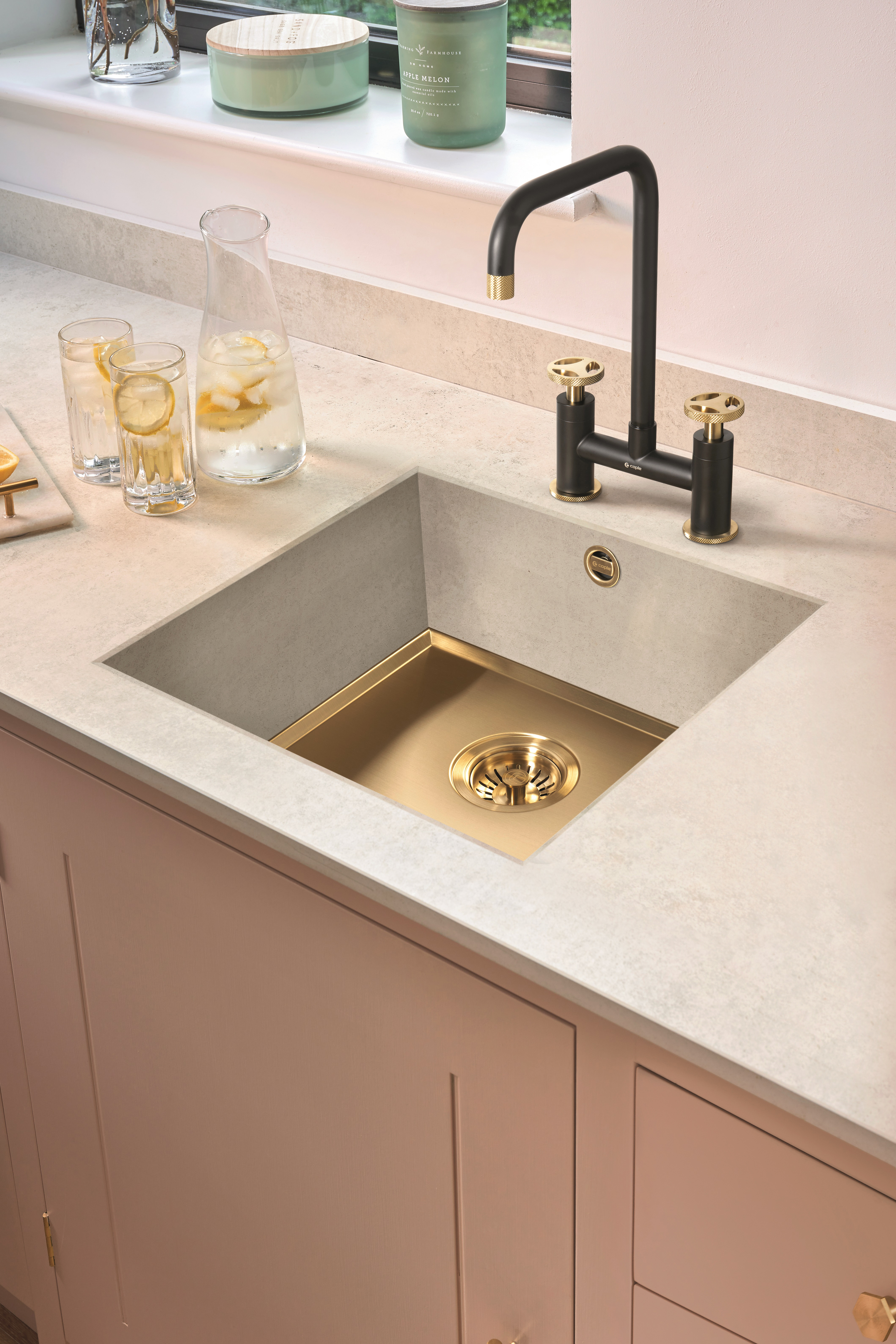 a black and bass kitchen tap with a brass sink base