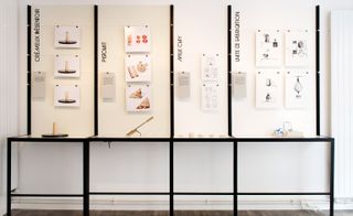A metal structure split into 4 sections with images pinned in each section. From left to right: Crémeux Presentoir by Romain Kloeckner; Pistolait by Victor Grenez, Paul Louda and Léo Tavoni; Milk Clay by Sijya Gupta; Unité de Fabrication by Lisa David, Laure Manhes, Jaïna Ennequin