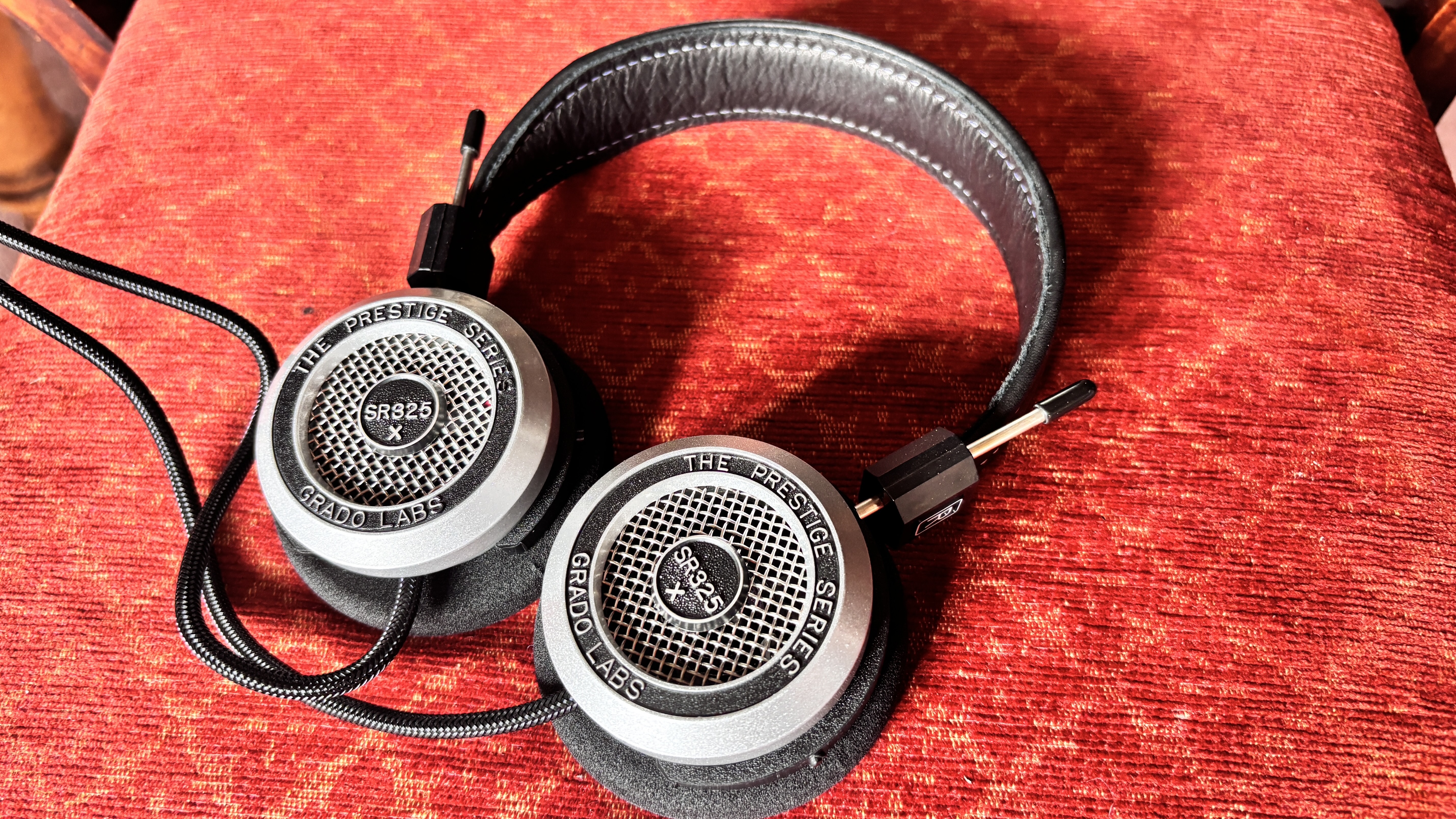 Grado SR325x wired on-ear headphones on a red fabric surface