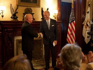 Vice President Joe Biden shakes hands with Captain Mark Kelly during his retirement ceremony in the Secretary of War Suite of the Eisenhower Executive Office Building, in Washington, D.C., Oct. 6, 2011. Kelly was presented the Legion of Merit and the Distinguished Flying Cross medals by the Vice President and Kelly's wife, U.S. Rep. Gabrielle Giffords, for his 25 years of service with the Navy and NASA.