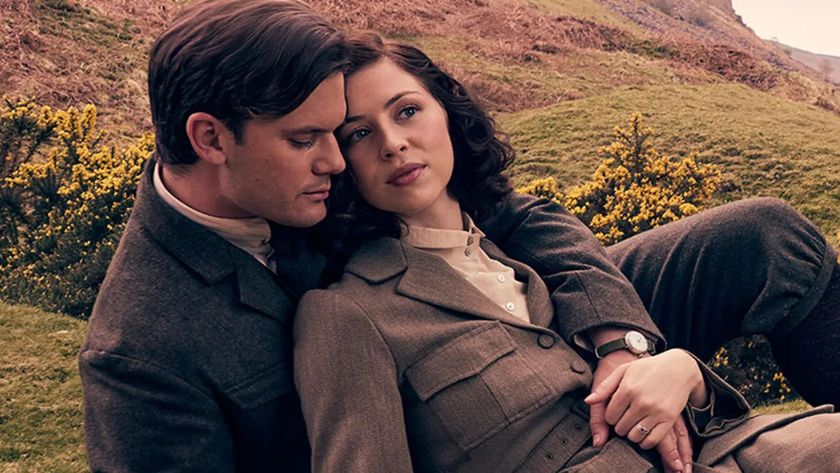 Henry embraces Julia while sitting in a field