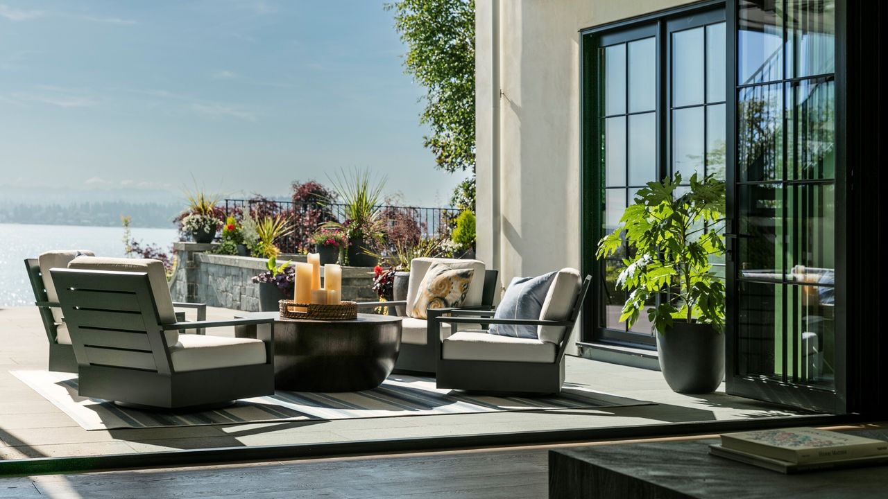 A backyard terrace with seating area overlooking a sea view