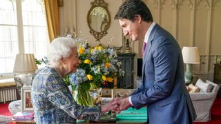 Britain's Queen Elizabeth II (L) shakes hands with Canadian Prime Minister Justin Trudeau as they meet for an audience at the Windsor Castle, Berkshire, on March 7, 2022.