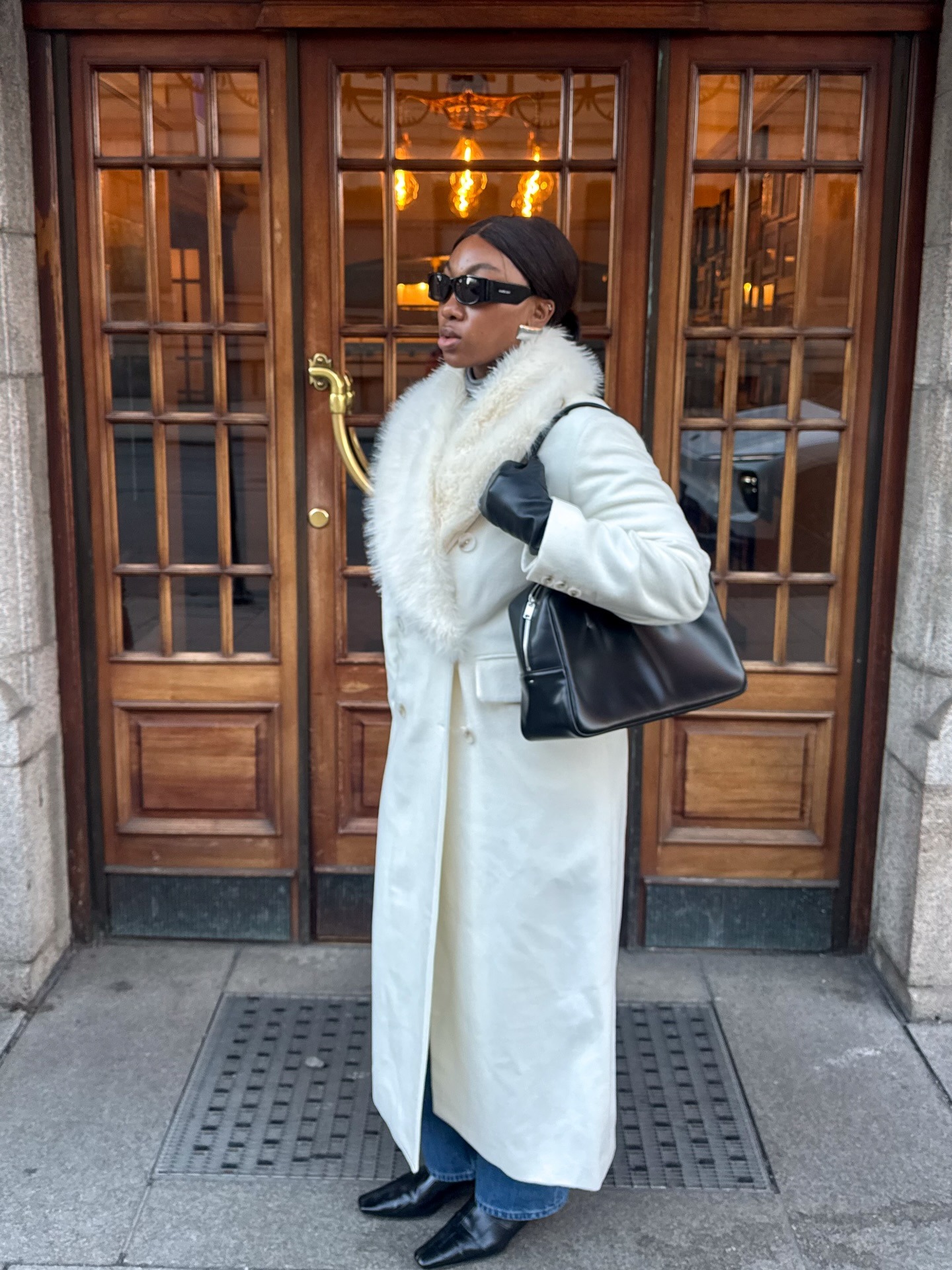 Woman wearing white ivory coat for winter 2026.