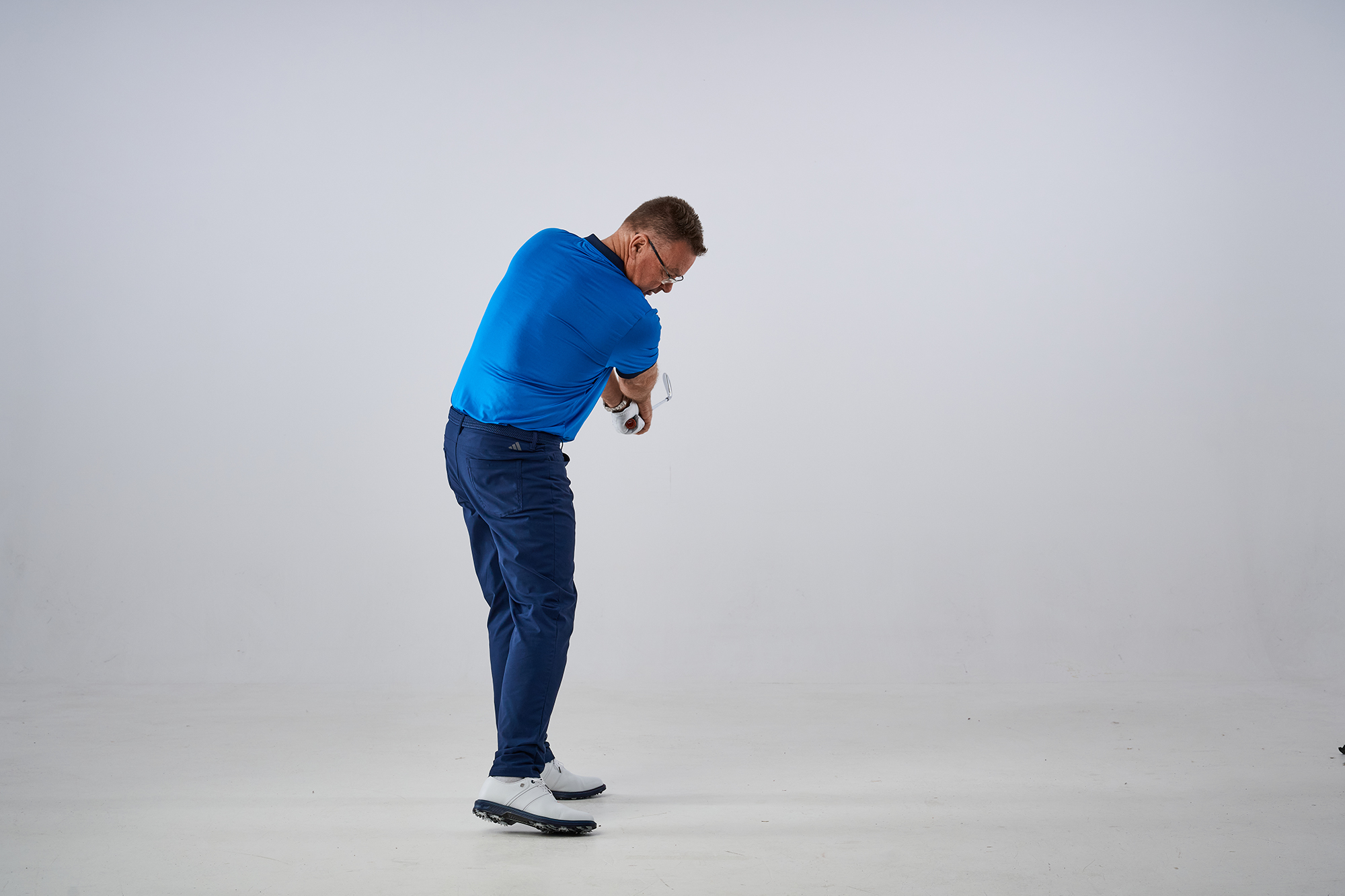 John Jacobs demonstrating the correct release position from down the line, with the hands rolling through and the club and chest rotating around past impact