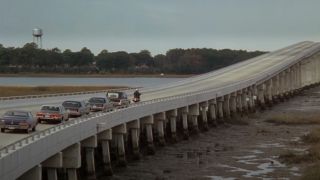 The funeral procession in The Big Chill driving over a long bridge