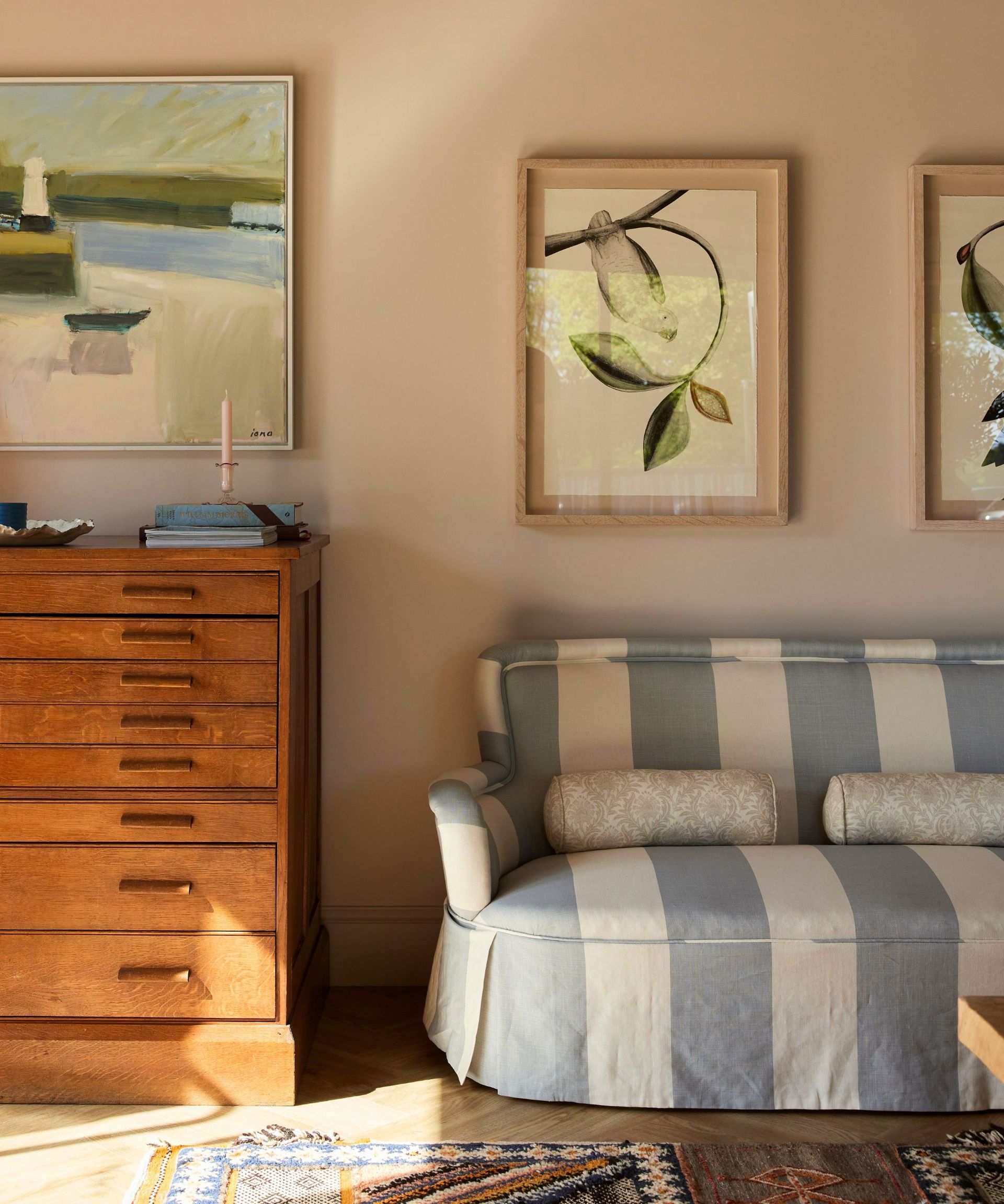 English country living room with a skirted sofa in Arthur stripe fabric by Cinny and a vintage chest of drawers