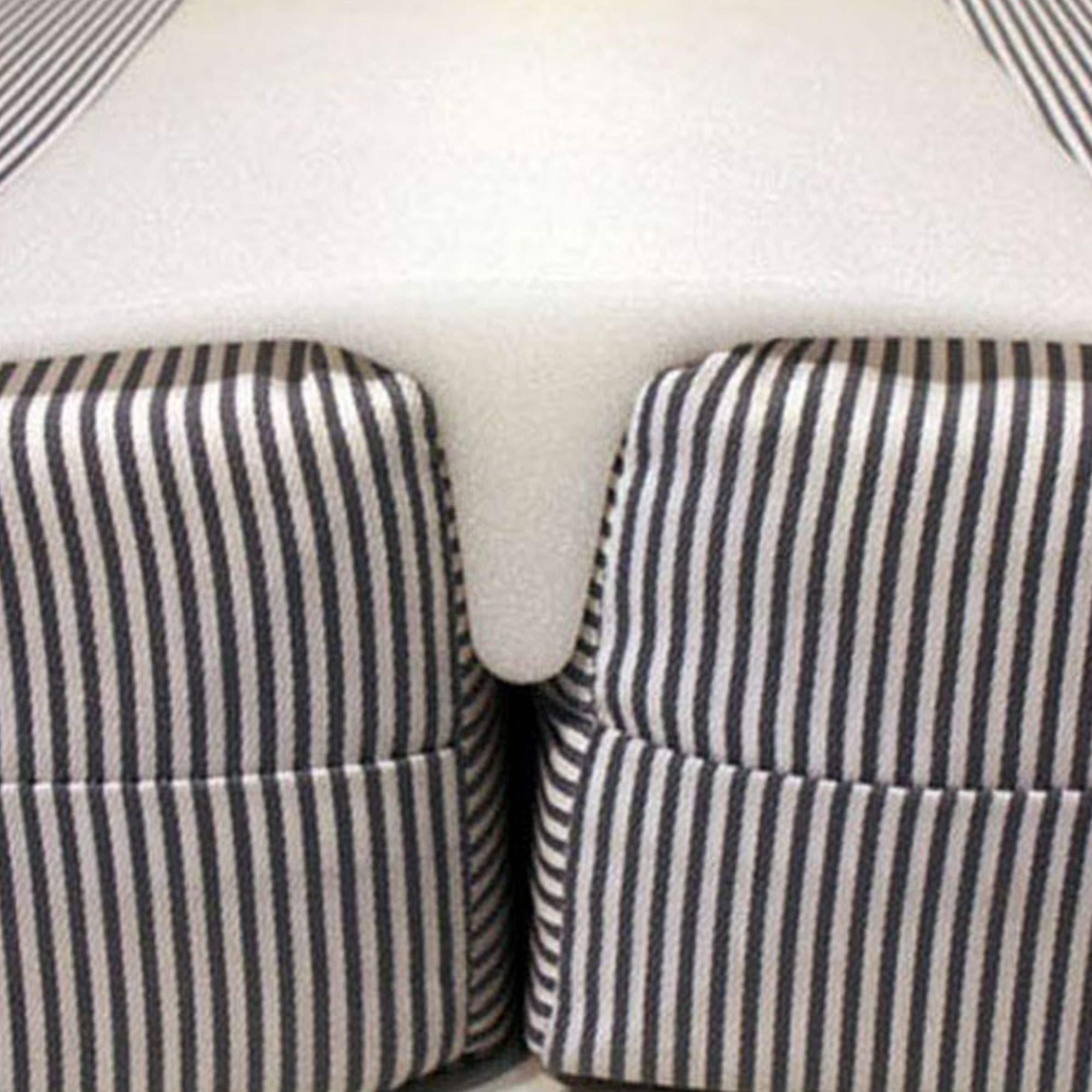 A white mattress gap filler pictured between two navy and white striped mattresses