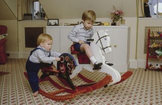 Prince Harry and Prince William playing on rocking horses as toddlers