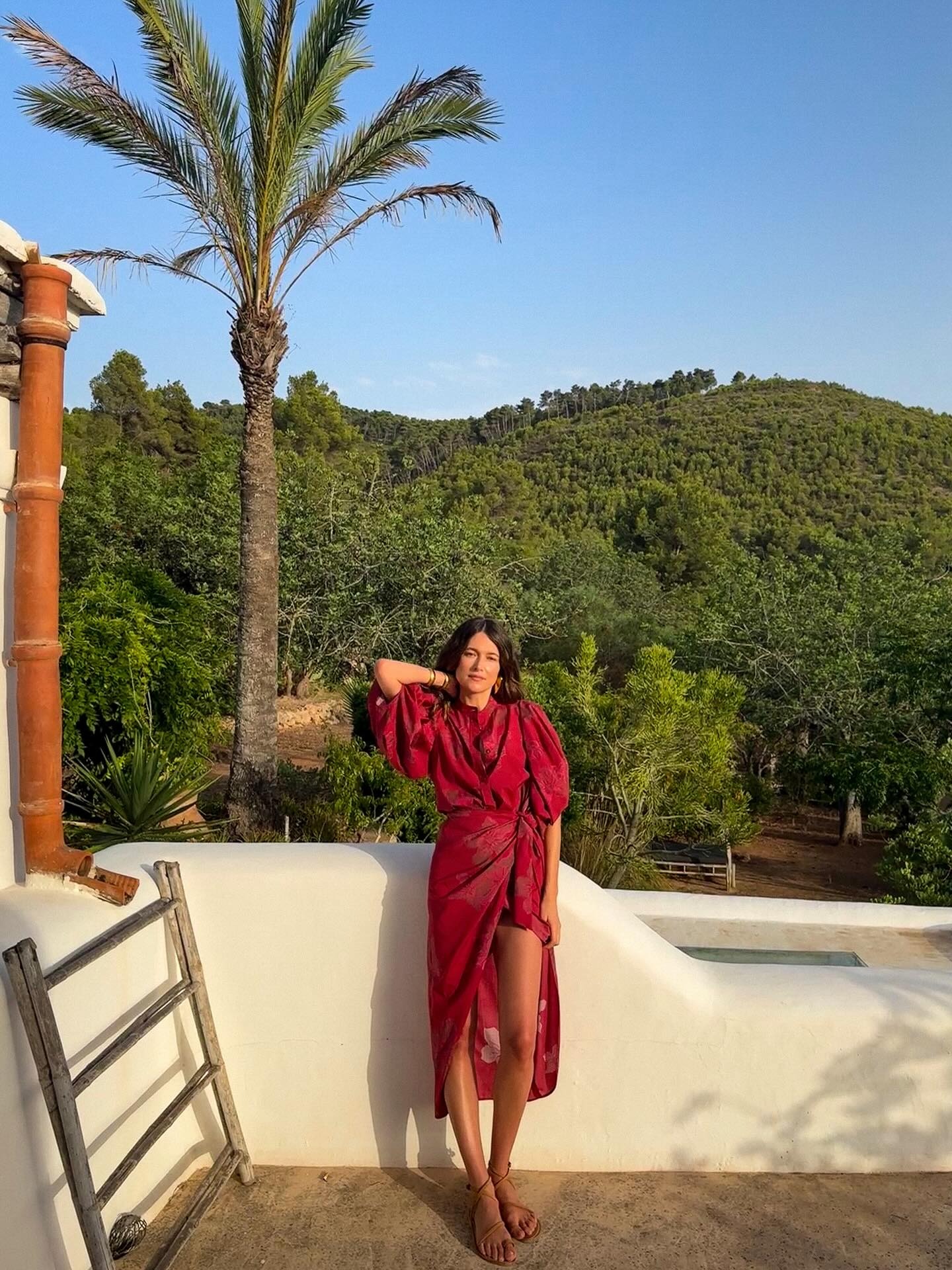 Fashion person Sara wears a red two piece set. she pairs it with tan strappy sandals in a recent image taken from her Instagram.