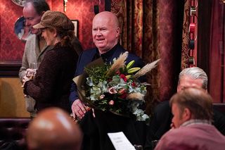 Phil with a bouquet of flowers in EastEnders 