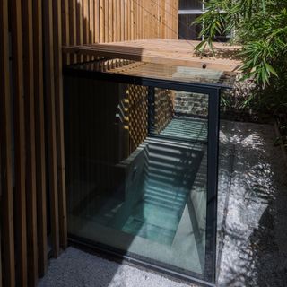 house extension with glass cabin and wooden plank wall