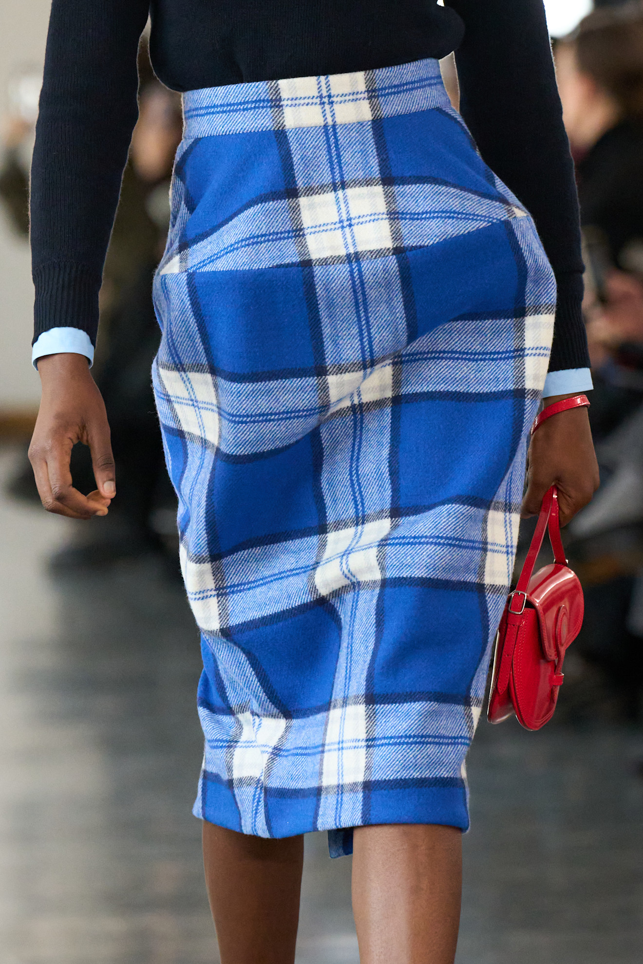 Bally model wears a blue plaid skirt.