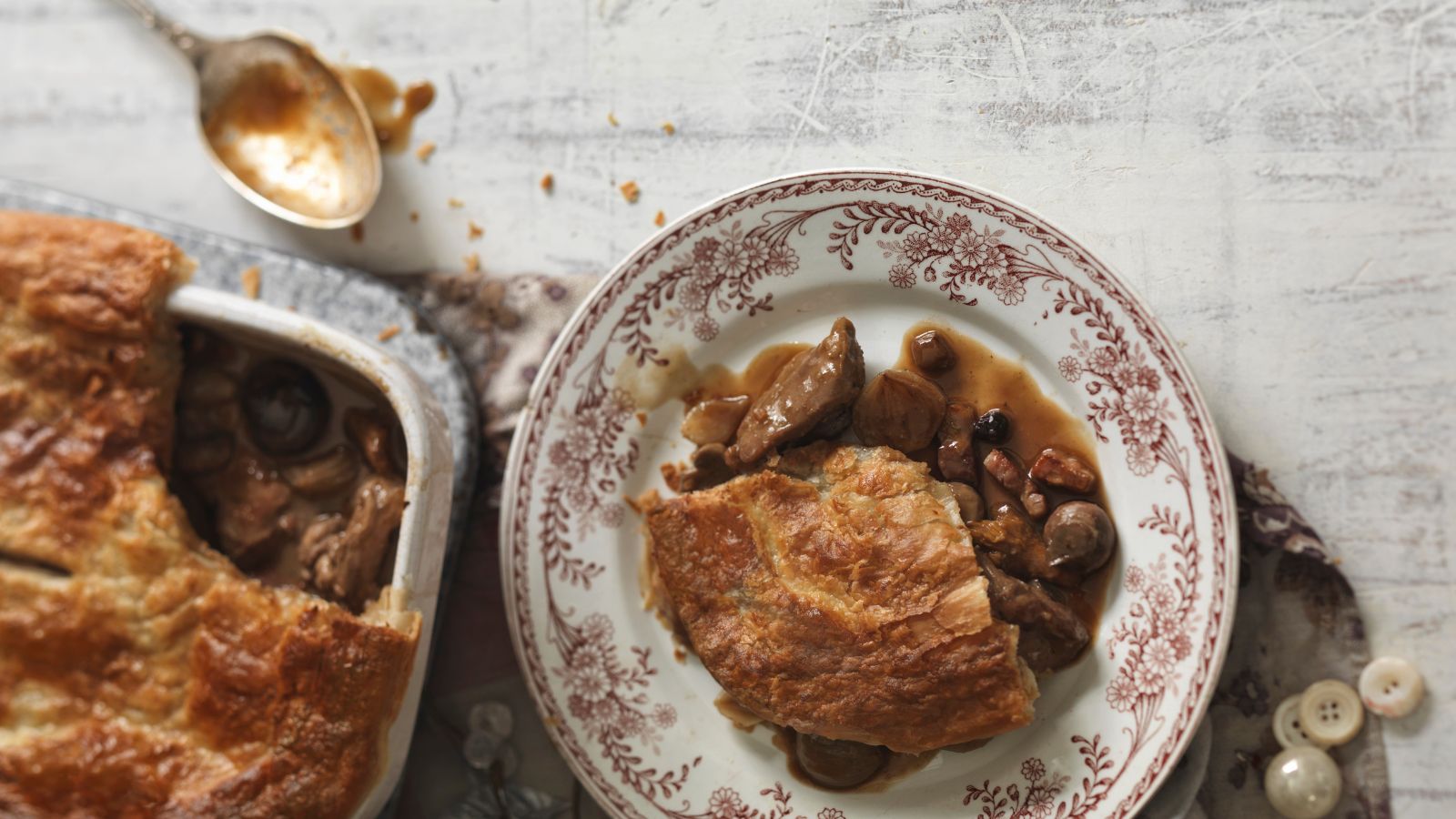 Savory pie served on white plate with maroon floral details
