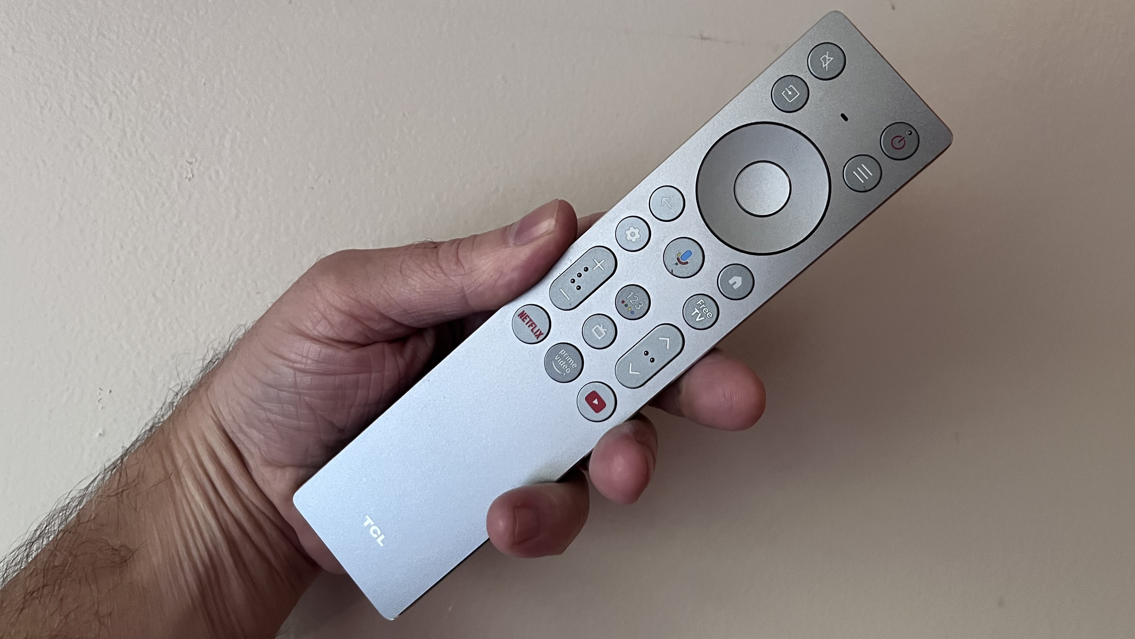 TCL QM9K remote control held in hand