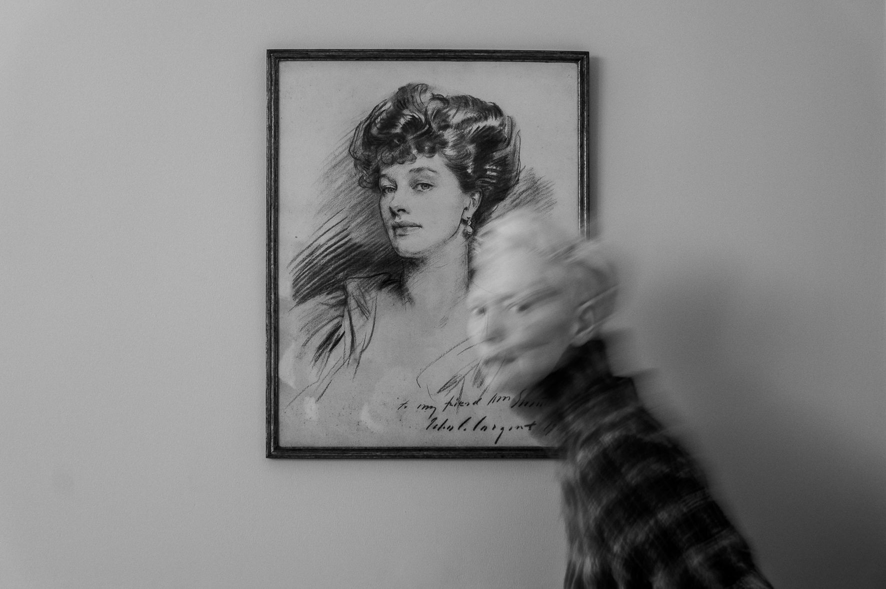 Tilda Swinton walking past a framed portrait