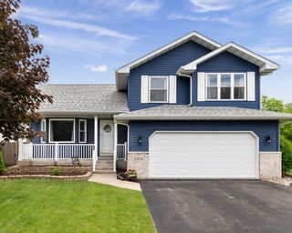 Exterior of a suburban home with blue siding, a white front porch, and white shutters