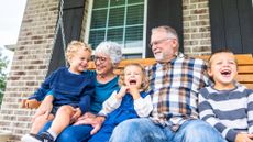 Grandparents and their grandchildren sitting on the home porch swing