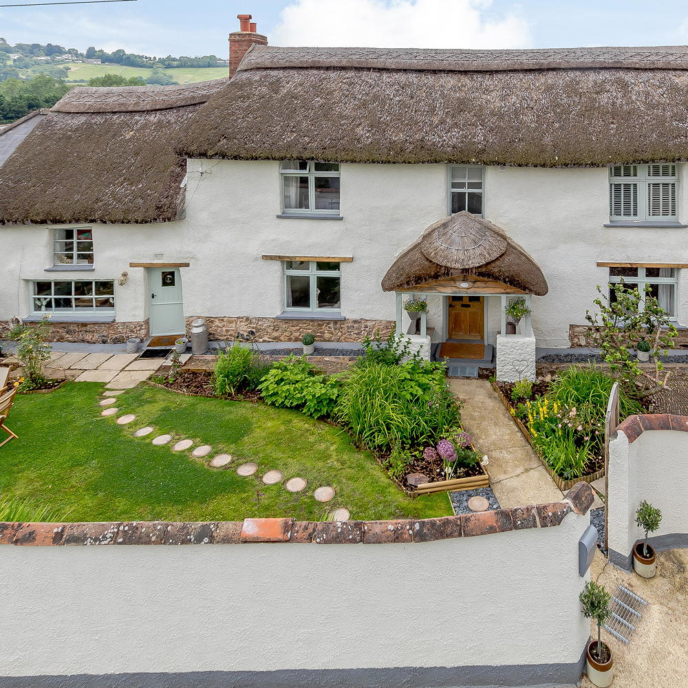 sloping roof house with exposed white walls and garden