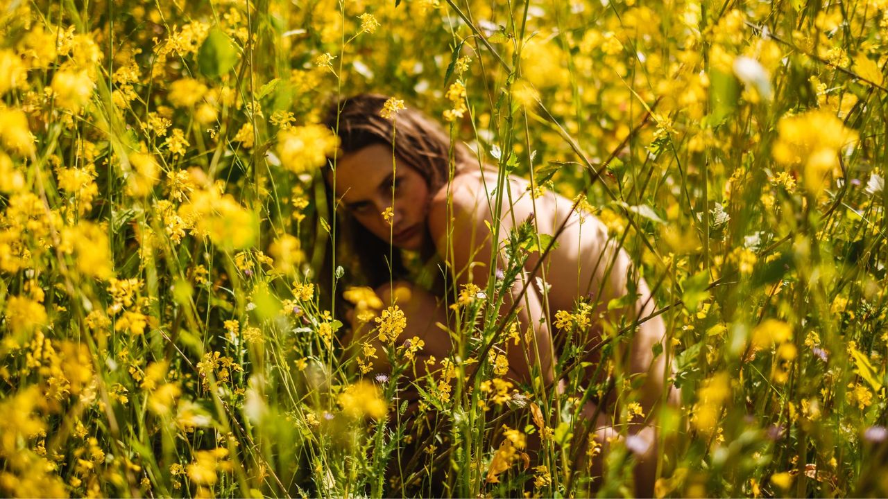 Solar perfumes: a woman in a yellow flower field under the sun